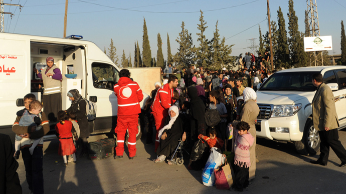 A handout picture released by the official Syrian Arab News Agency (SANA) on October 12, 2013 shows Syrian women and children arriving to be evacuated by Syria's Red Crescent from a Damascus suburb  (AFP Photo)