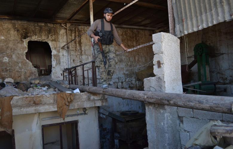 An opposition fighter walks along a log in the northern Syrian city of Aleppo on 6 October 2013. (Photo: AFP - Tarek Abu al-Fahem)