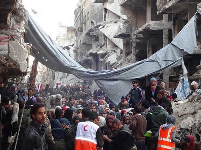 Crowds of potential recipients of aid waiting to be allowed to proceed across the frontline in Yarmouk area of Damascus to join the queue at the distribution area on Rama Street. (Photo: UNRWA/file) 