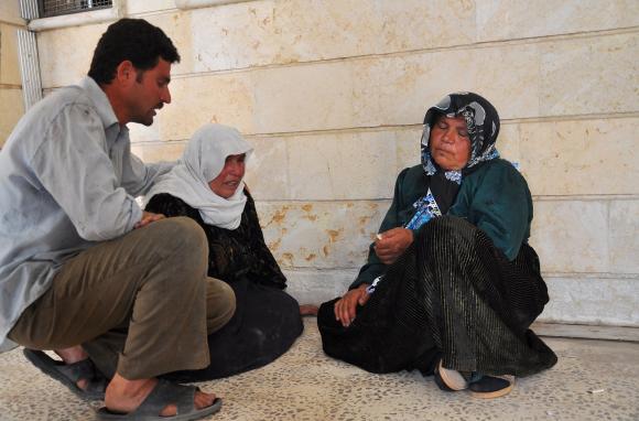  A man comforts a woman after activists said people were killed by the Islamic State in Iraq and the Levant (ISIL), in a village near Ras al-Ain city in Hasakah province May 29, 2014. Credit: Reuters/Massoud Mohammed 