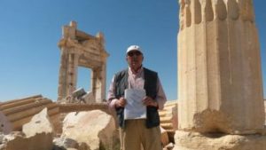 Tour guide “Tony” in front of the ruins of the Temple of Baal blown up by Daesh. He’s holding a drawing of the temple as it used to appear. (Photo credit: Jeff Klein)